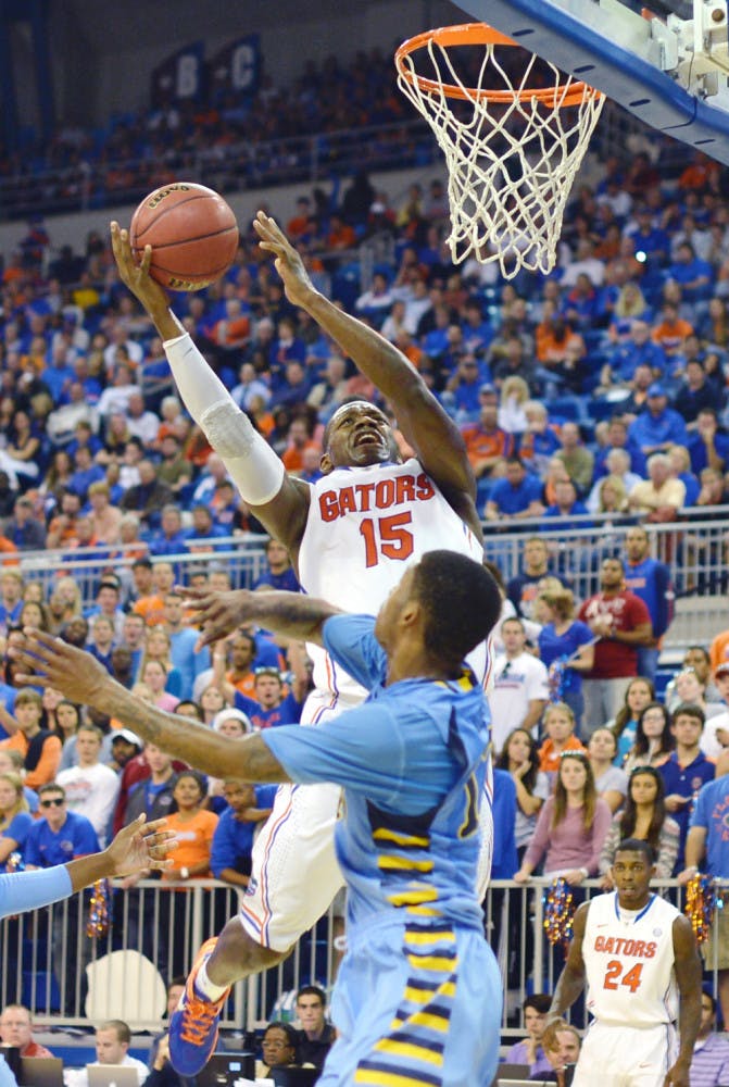 Senior forward Will Yeguete attempts a layup over Marquette guard Vander Blue during Florida’s 82-49 victory against the Golden Eagles on Nov. 29 at the O’Connell Center. Yeguete averaged 5.5 points per game last season.