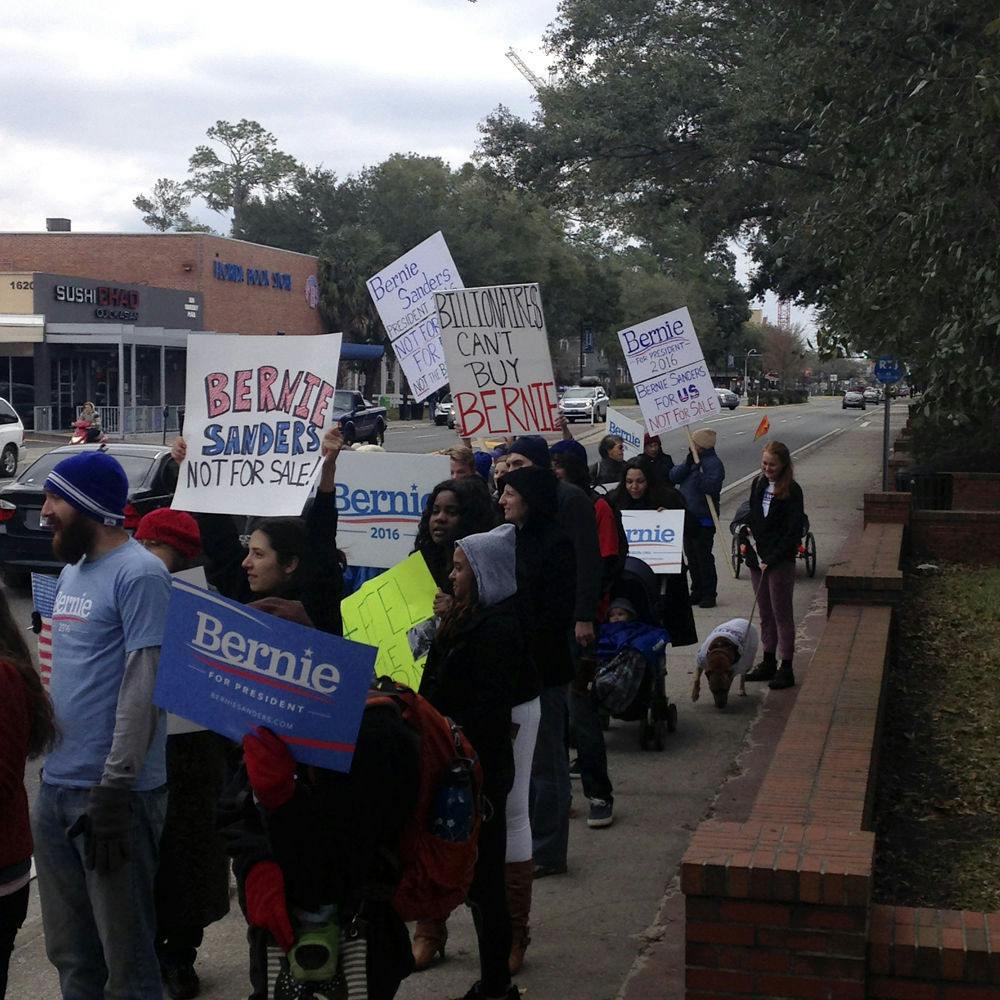 <p>Bernie Sanders supporters walk west on University Avenue on Saturday. About 60 students and Gainesville residents carried posters and marched across UF’s campus to show their support for Sanders’ presidential campaign.</p>