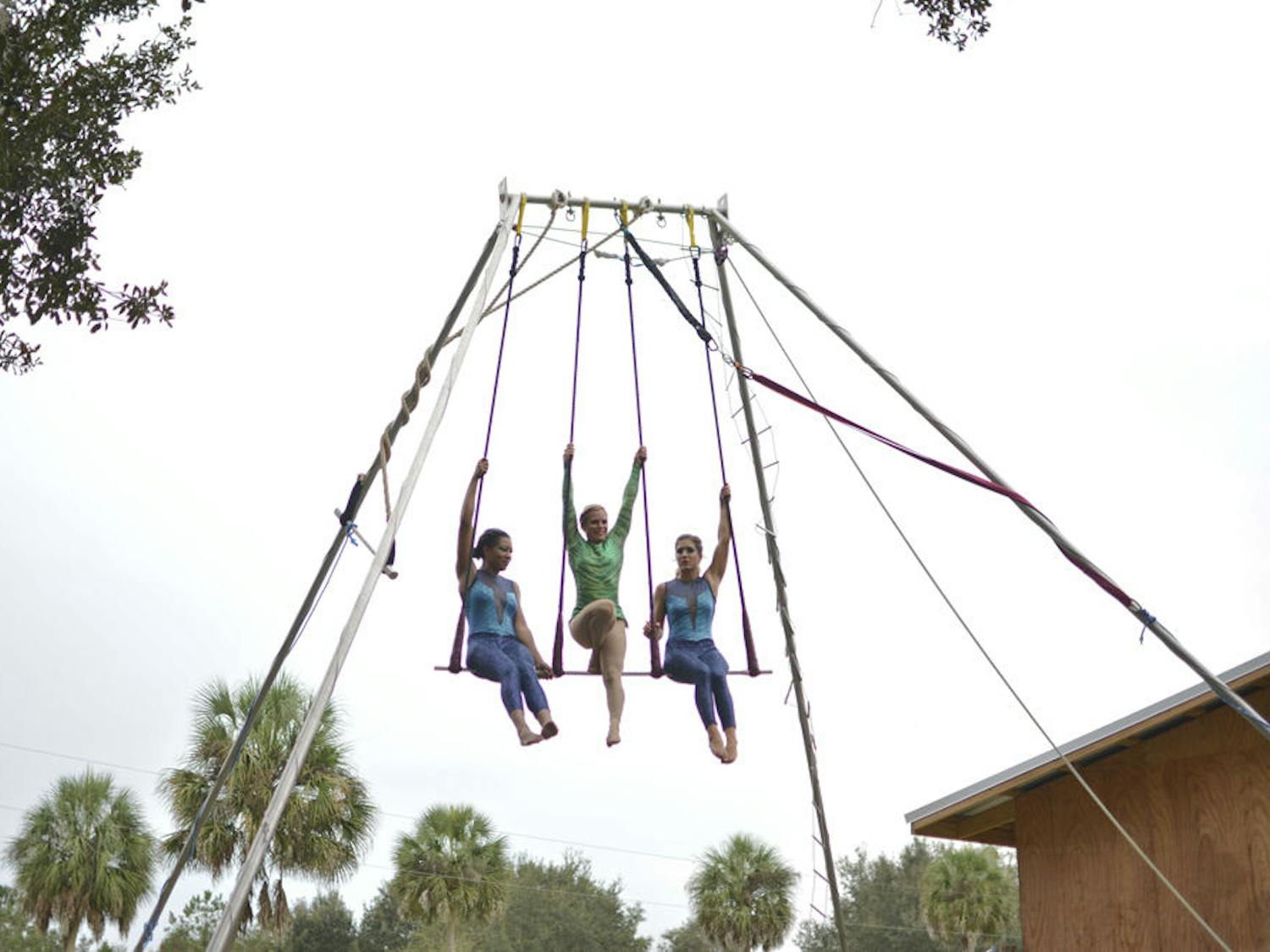From left to right, Tatyana Kimble, Becca Burton, and Kelly Ulmer perform trapeze at the “Country Circus: Aquatic Dream Show” at Two Hawk Hammock in Williston on Nov. 21, 2015.