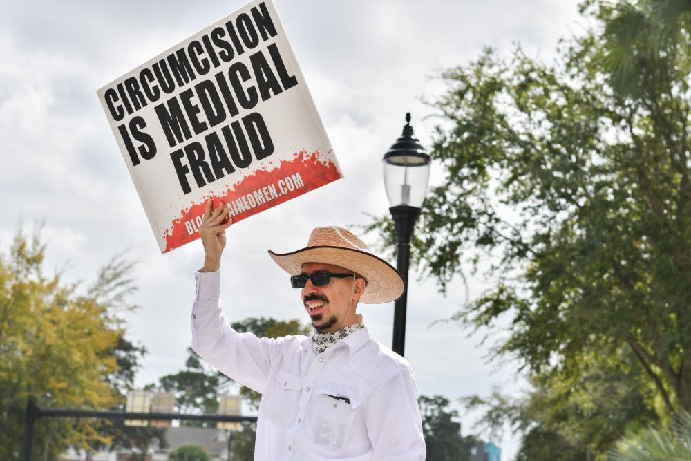 Jonathan Friedman, a 31-year-old activist, chants “I want my foreskin back” Monday morning at the intersection of 13th Street and University Avenue. Friedman is a member of the Bloodstained Men, an activist group that has been traveling across the United States to protest the circumcision of boys at birth.  