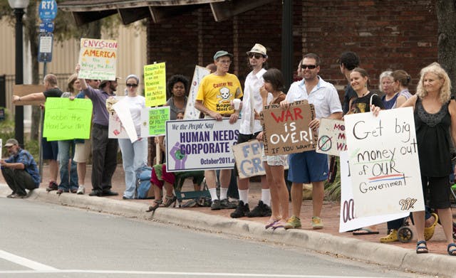 Occupy Gainesville protesters line University Avenue on Wednesday. The protesters who still occupy Bo Diddley Community Plaza live off organic and local food deliveries.