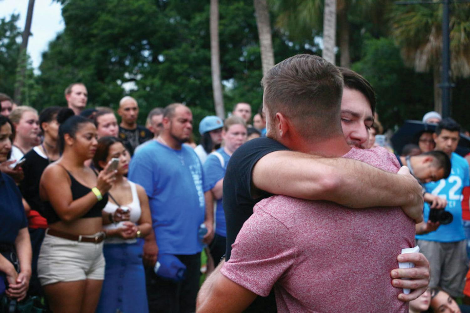 The organizer of a vigil for the victims of the Orlando nightclub shooting, Mitch Foster, 30, embraces Carlos Perez, 26, at Lake Eola Park on Sunday. “I needed to be surrounded by people who I knew were hurting as well, and that cared and that needed help, because I needed help,” Perez said.