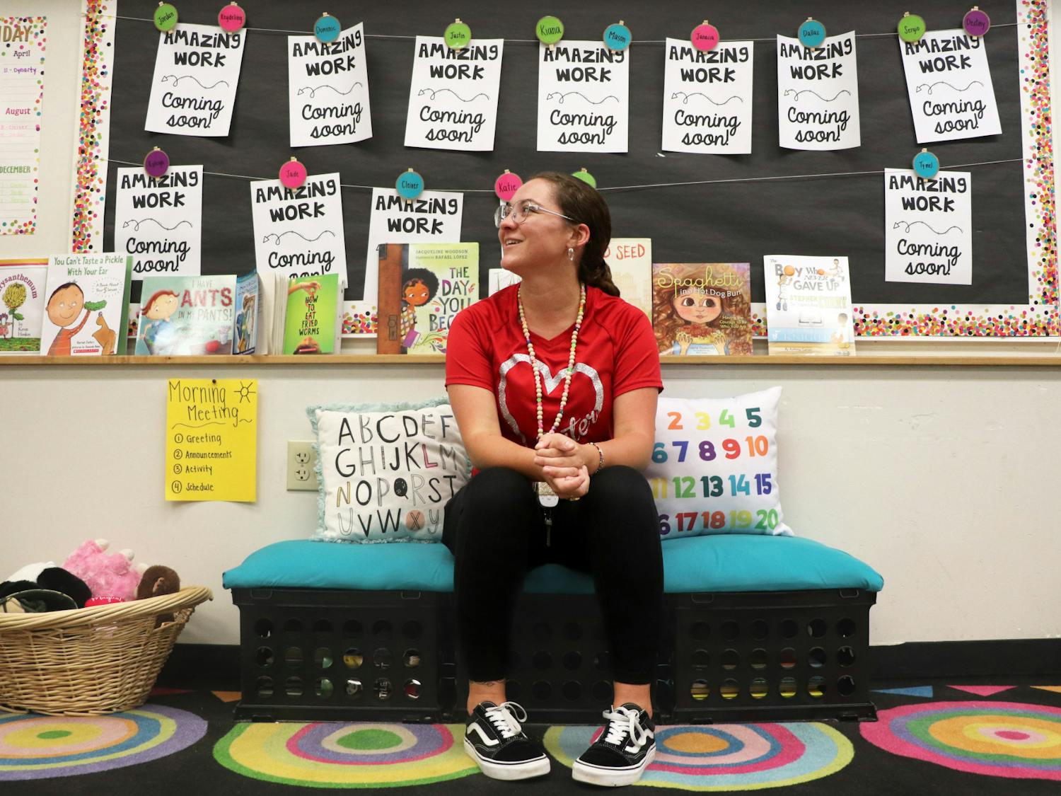 Third grade teacher Alayna Schwenker sits on a hand-made bench in the library corner of her classroom at Stephen Foster Elementary School Sept. 8, 2023.