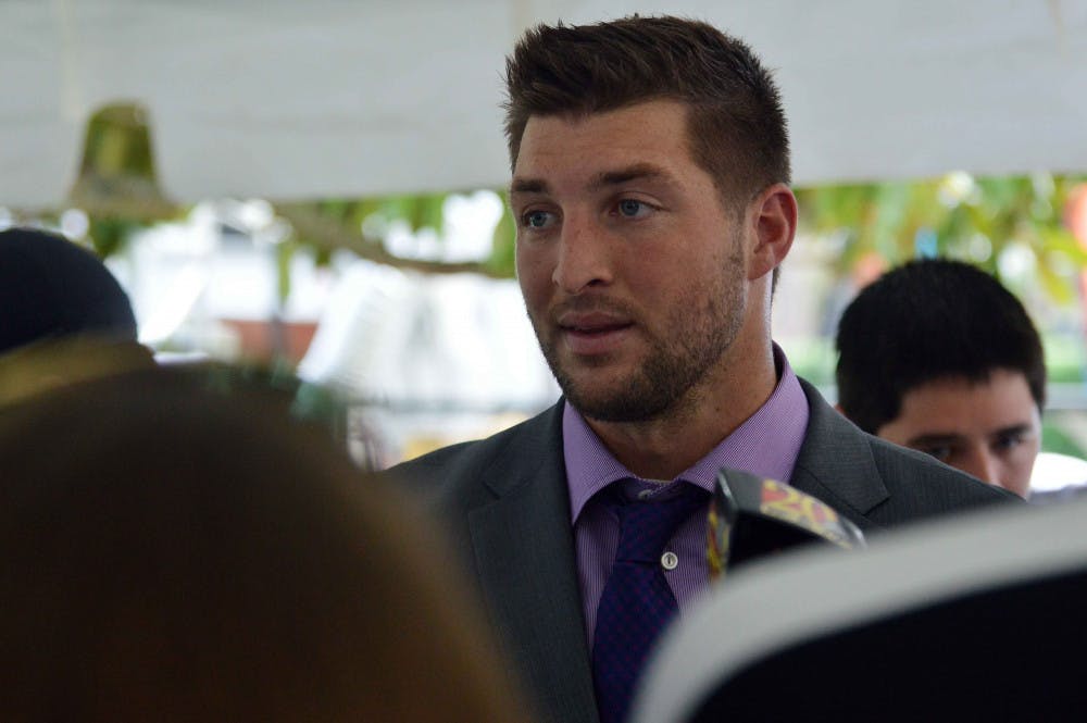 <p>Former Florida quarterback Tim Tebow speaks with media on UF's Plaza of the Americas in September 2014.</p>