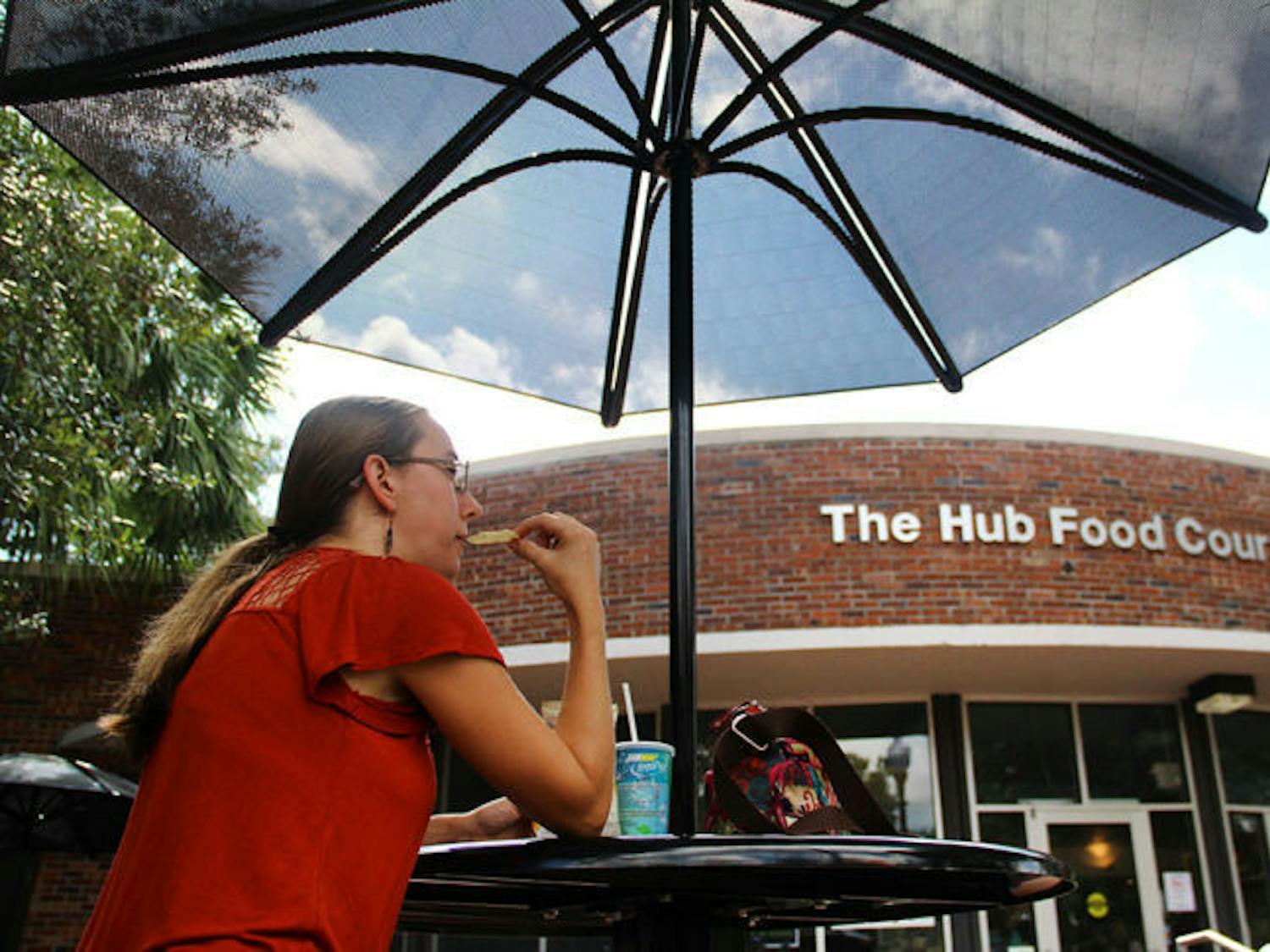 Sedonia Steininger, a 32-year-old first-year entomology and nematology master’s student, eats lunch under an umbrella outside the Hub on Tuesday afternoon. Some students are choosing to avoid the Reitz Union because of construction.