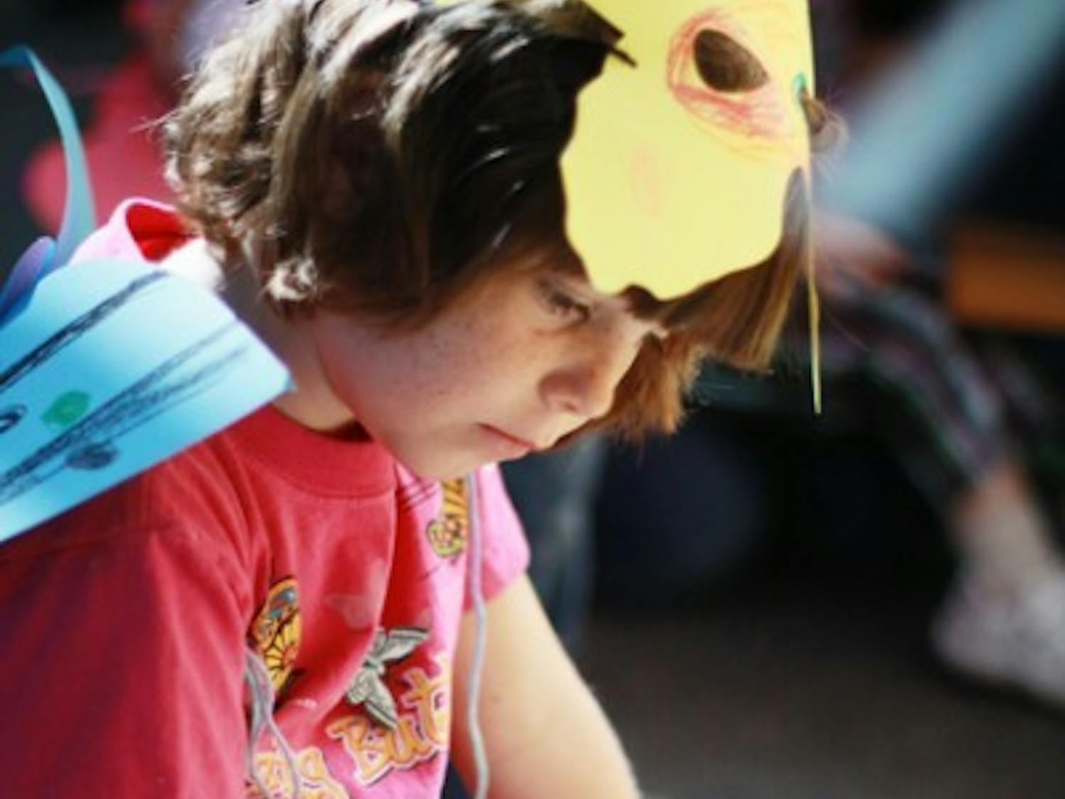 Sarah Whitin, 6, looks at some moths and butterflies on display at ButterflyFest at the Florida Museum of Natural History on Saturday.