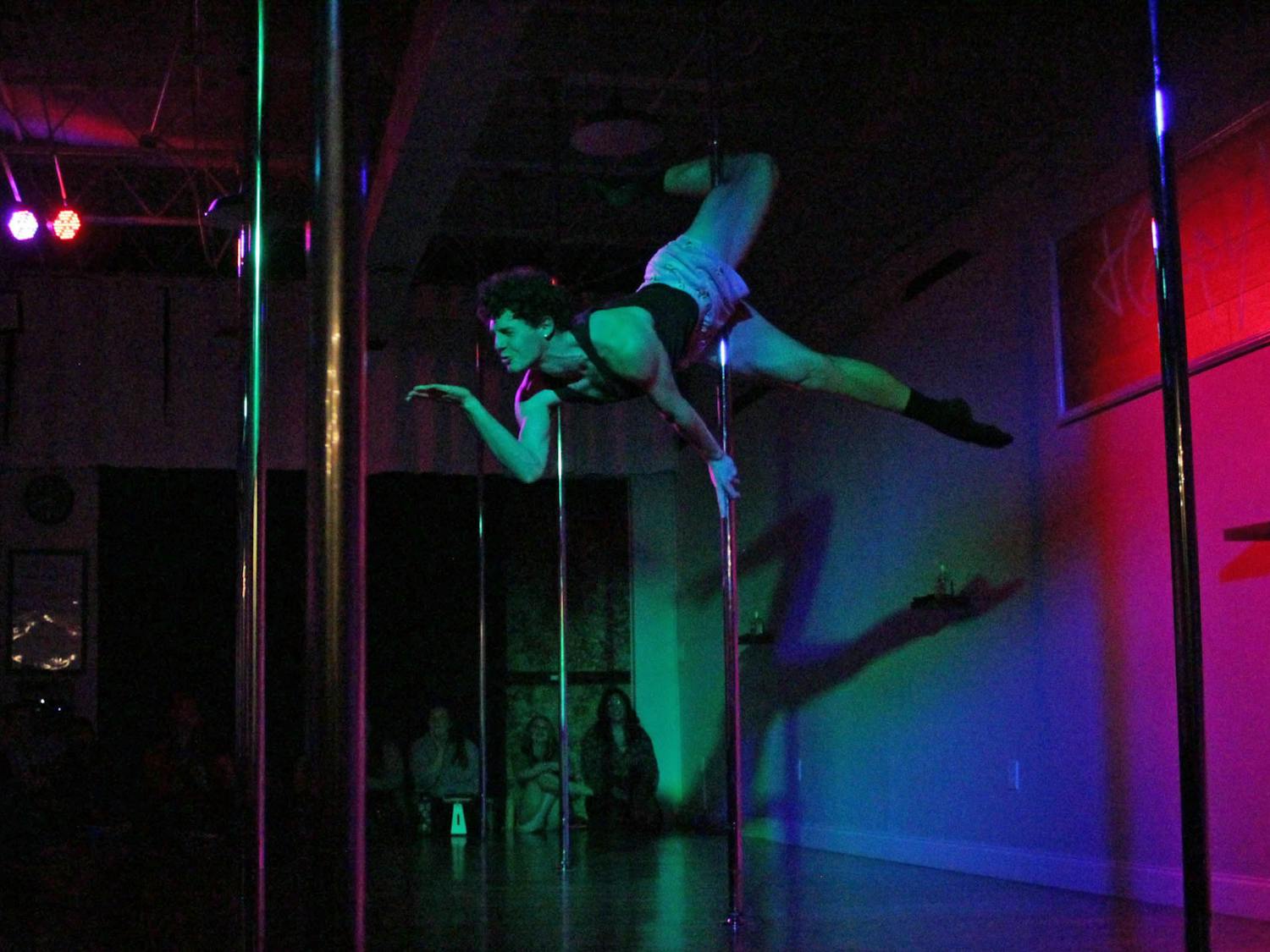 Nathan Wydra dances as the opening act to Happy Kiss Pole Fitness’ Jingle Jam and Showcase on Friday, Dec. 1, 2023.