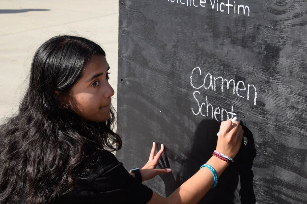 MSD alum Anisha Saripalli, an 18-year-old biomedical engineering sophomore and the March for Our Lives Gainesville treasurer, writes the name of her friend down on the gun violence victim board. Carmen Schentrup was a Marjory Stoneman Douglas student who died in the shooting just days after she was accepted into UF.