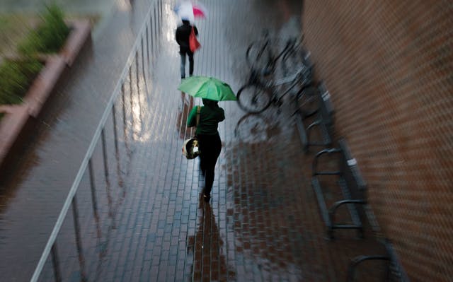 Students rush to class as torrential rainfall and thunderstorms cast gray clouds over Gainesville.