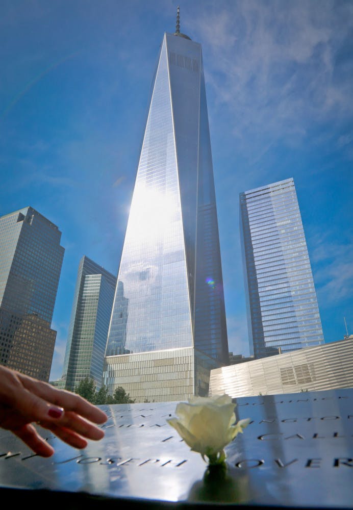 A visitor reaches to touch a name engraved at the Sept. 11 memorial site to remember the victims of the 2001 attacks on the World Trade Center, Thursday Sept. 8, 2016, in New York. Sunday marks the 15th anniversary of the terror attacks.