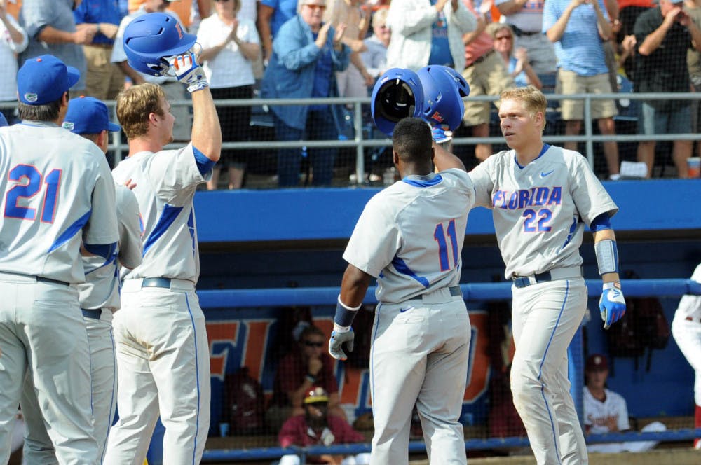 JJ Schwarz celebrates with teammates at home plate after hitting the first of his two home runs during Florida's 11-4 win against Florida State on June 6, 2015, at McKethan Stadium.