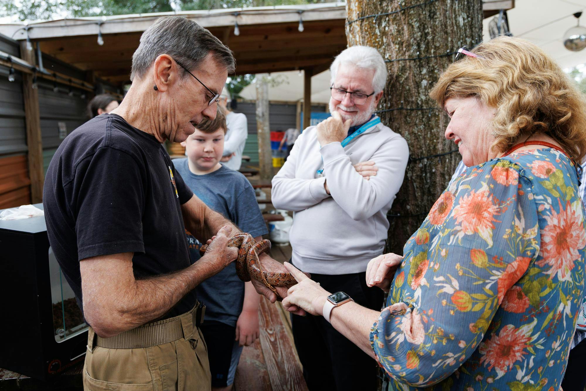 Sunrise Wildlife Rehabilitation director Joe Soistman holds Kernel, a corn snake, while Stacy Richards pets the snake at the Florida Master Naturalist Program’s 25-year anniversary celebration in Gainesville, Fla., Saturday, Jan. 17, 2026.