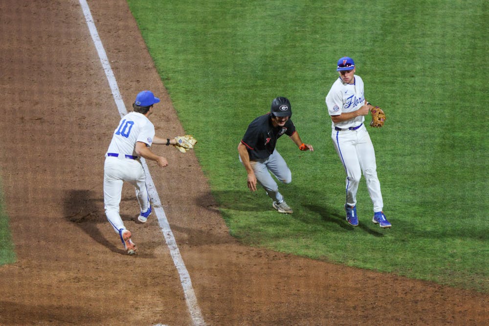 Florida pitcher Tyler Nesbitt tries to tag the runner in the Gators' 14-11 loss to the Georgia Bulldogs Friday, April 14, 2023. 