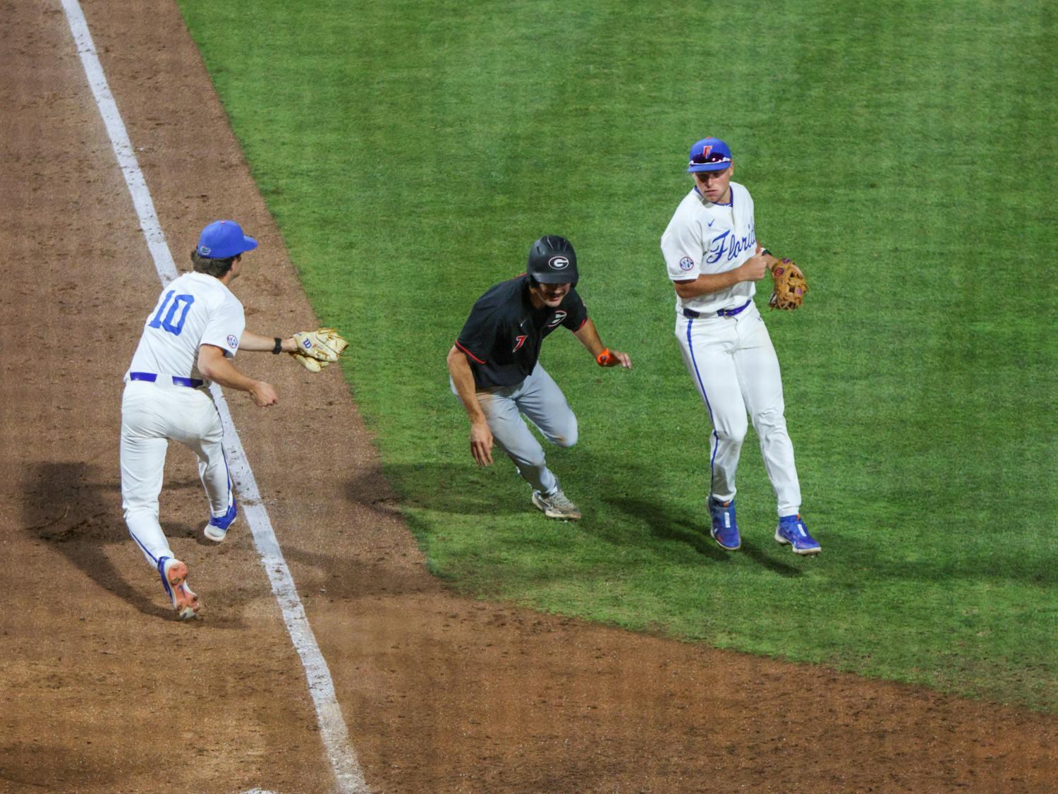 Florida pitcher Tyler Nesbitt tries to tag the runner in the Gators' 14-11 loss to the Georgia Bulldogs Friday, April 14, 2023.