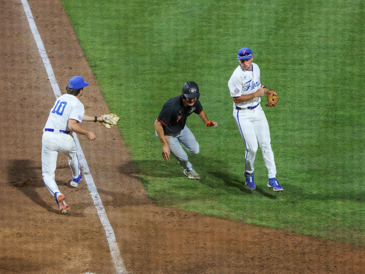 Florida pitcher Tyler Nesbitt tries to tag the runner in the Gators' 14-11 loss to the Georgia Bulldogs Friday, April 14, 2023. 