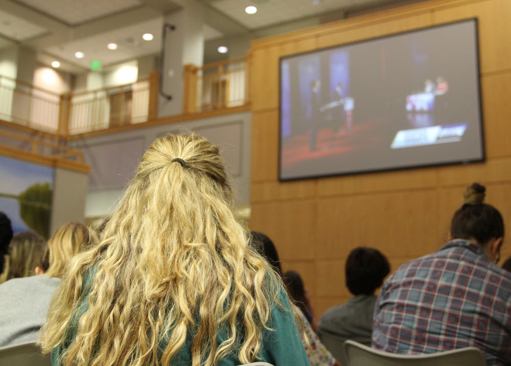 Grace Banahan, an 18-year-old political science and journalism major, listens to Florida Governor candidates Ron DeSantis and Andrew Gillum debate on corruption and racism Wednesday night at the Governor's Debate Watch Party in Pugh Hall. Banahan is voting for her first time this year. 