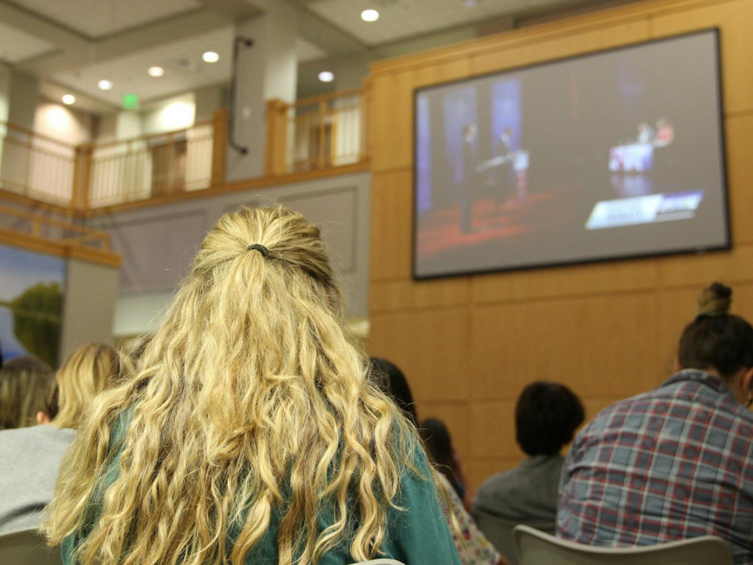 Grace Banahan, an 18-year-old political science and journalism major, listens to Florida Governor candidates Ron DeSantis and Andrew Gillum debate on corruption and racism Wednesday night at the Governor's Debate Watch Party in Pugh Hall. Banahan is voting for her first time this year.