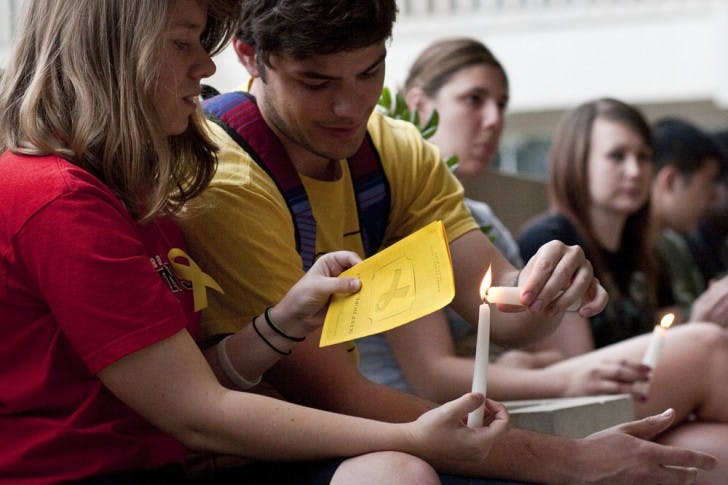 Jordan Agrippe, a 21-year-old psychology senior, and Robert Bolduc, a 22-year-old criminology senior, light candles at the Keep Hope Alive suicide awareness vigil Thursday evening. Eighty-five candles were lit in remembrance of people who commit suicide every day.