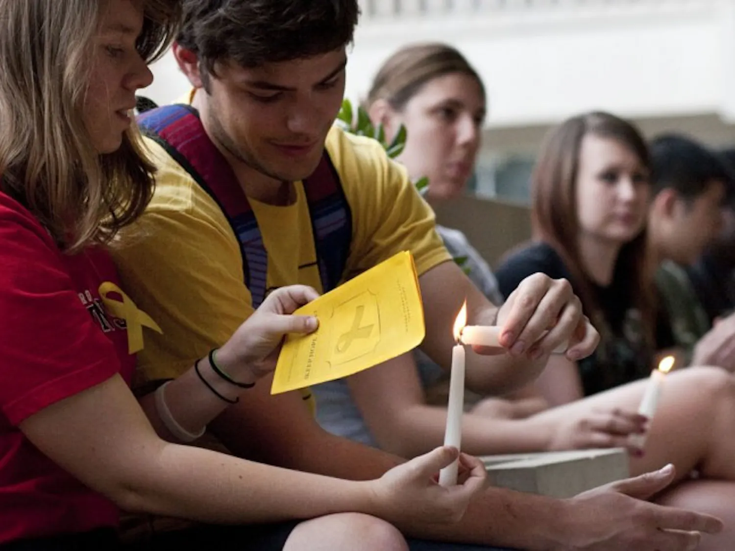 Jordan Agrippe, a 21-year-old psychology senior, and Robert Bolduc, a 22-year-old criminology senior, light candles at the Keep Hope Alive suicide awareness vigil Thursday evening. Eighty-five candles were lit in remembrance of people who commit suicide every day.