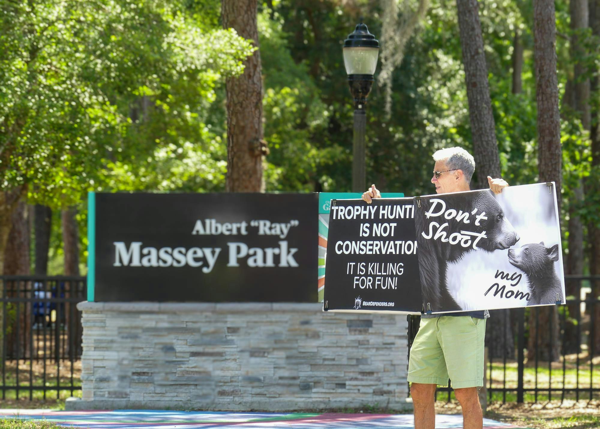 A protester outside of Massey Park calls for an end to bear hunting on Saturday, May 17, 2025.