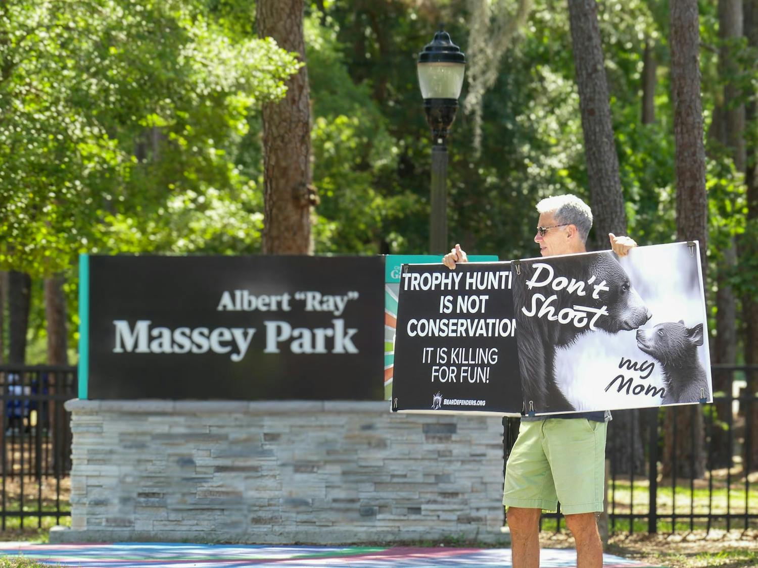 A protester outside of Massey Park calls for an end to bear hunting on Saturday, May 17, 2025.