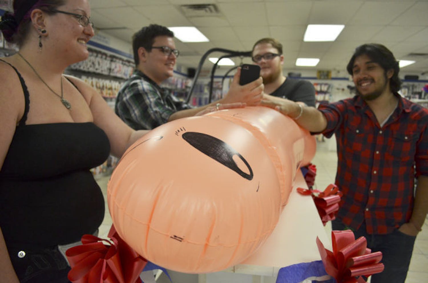 Contestants gather around a five-and-a-half foot long inflated penis for X-Mart’s “Longest Handy Ever Contest” held Saturday at the store.&nbsp;
&nbsp;
