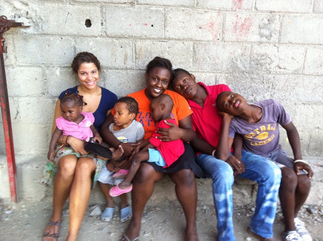 McNair Scholars Jasmine Wright and Bertrhude Albert pose with orphans at the H.O.P.E. Center in Haiti.