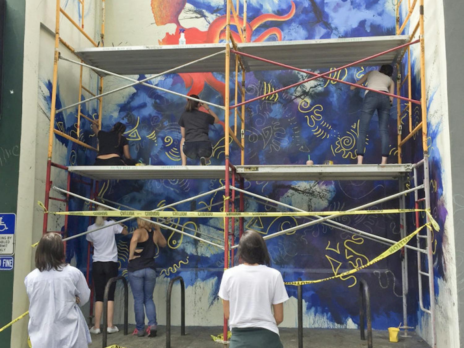 Students enrolled in the UF College of Arts class, Site Specific Painting, collaborated with 352Walls to paint a mural at the Sun Center in downtown Gainesville, located at 101 SE Second Place.
