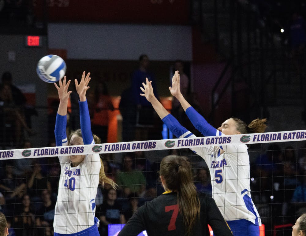 <p>Right side hitter/setter Holly Carlton and middle blocker Rachael Kramer extend for a block during UF's 3-1 loss to Southern California Friday.</p>