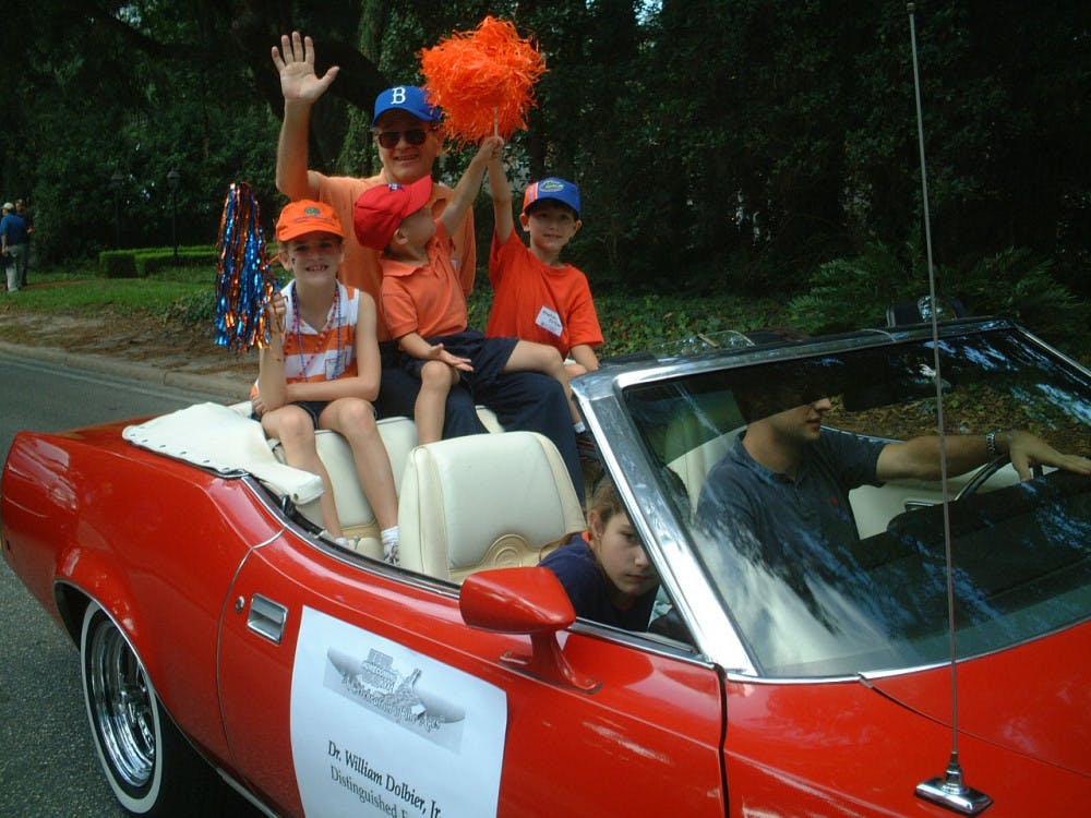 William Dolbier rides a parade float in 2003 with his granddaughter on the left, his nephew in the middle and his son on the right. He was honored with this float at the parade after winning the Distinguished Faculty Award with Florida Blue Key in 2003.
