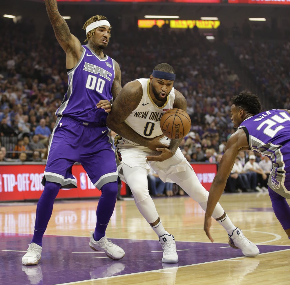 Sacramento Kings guard Buddy Hield, right, hits the ball out of the hands of New Orleans Pelicans forward DeMarcus Cousins, center, as Kings center Willie Cauley-Stein defends during the first quarter of an NBA basketball game Thursday, Oct. 26, 2017, in Sacramento, Calif. (AP Photo/Rich Pedroncelli)