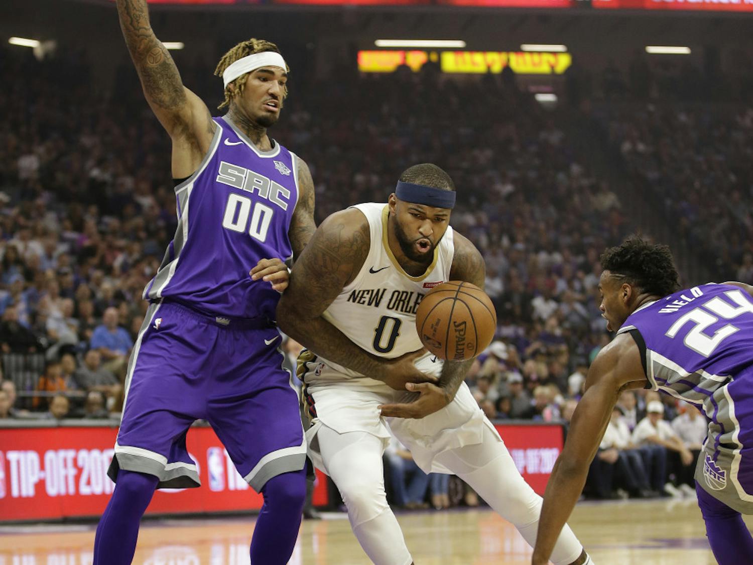 Sacramento Kings guard Buddy Hield, right, hits the ball out of the hands of New Orleans Pelicans forward DeMarcus Cousins, center, as Kings center Willie Cauley-Stein defends during the first quarter of an NBA basketball game Thursday, Oct. 26, 2017, in Sacramento, Calif. (AP Photo/Rich Pedroncelli)