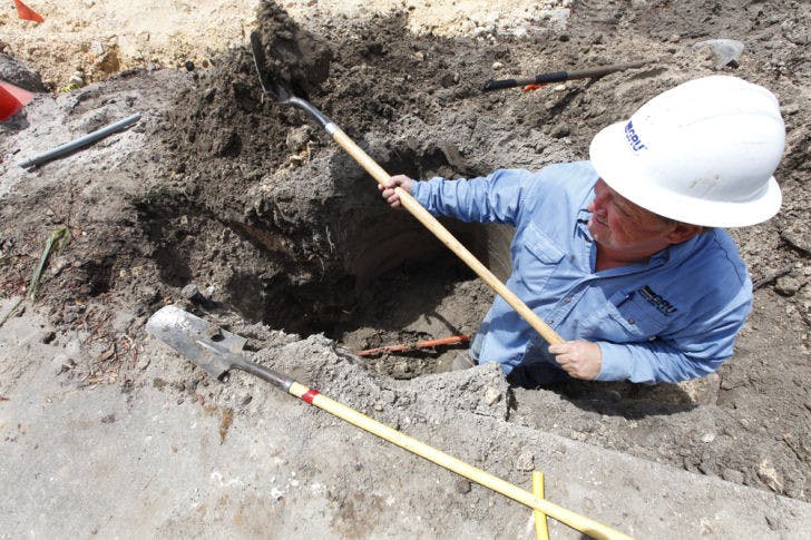 A gas worker for Gainesville Regional Utilities, digs around a broken gas line.