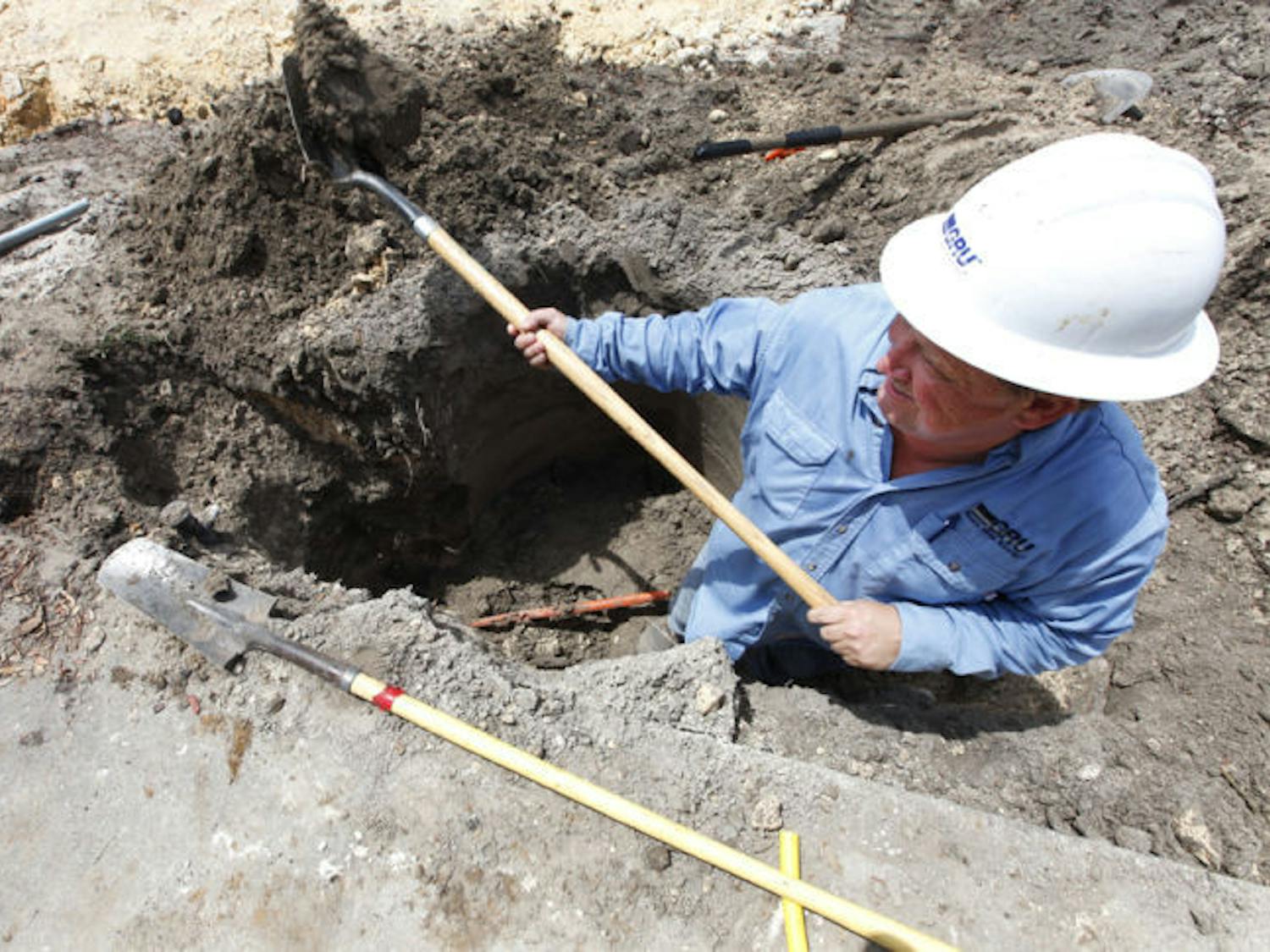 A gas worker for Gainesville Regional Utilities, digs around a broken gas line.