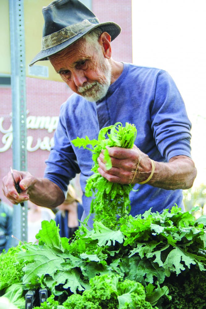 John Steyer, 80, sorts through his vegetables in preparation for the farmers market. Steyer said he grows all of his crops on 24 acres of land.