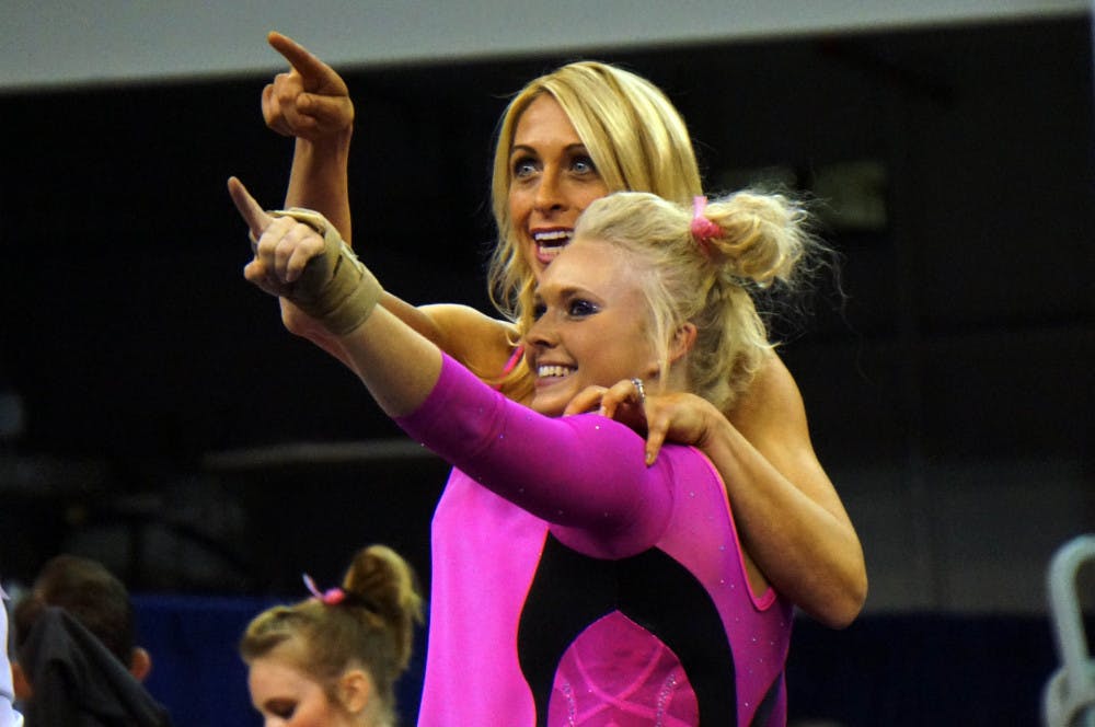 Rachel Spicer and coach Rhonda Faehn point to Spicer's mom in the O'Connell Center crowd during Florida's win against Kentucky on Friday.