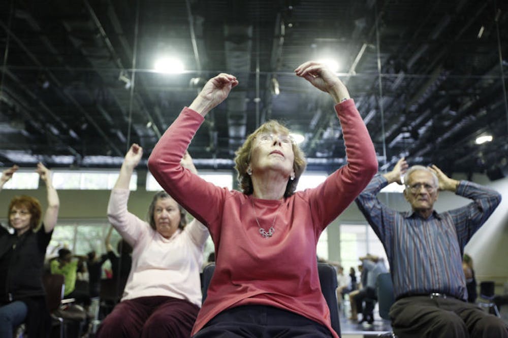 <p>Ellie Schmidt, 80, dances in a chair during a Dance for Life class in the Nadine McGuire Theatre and Dance Pavilion on Friday morning. The program aims to help Parkinson’s disease patients.</p>