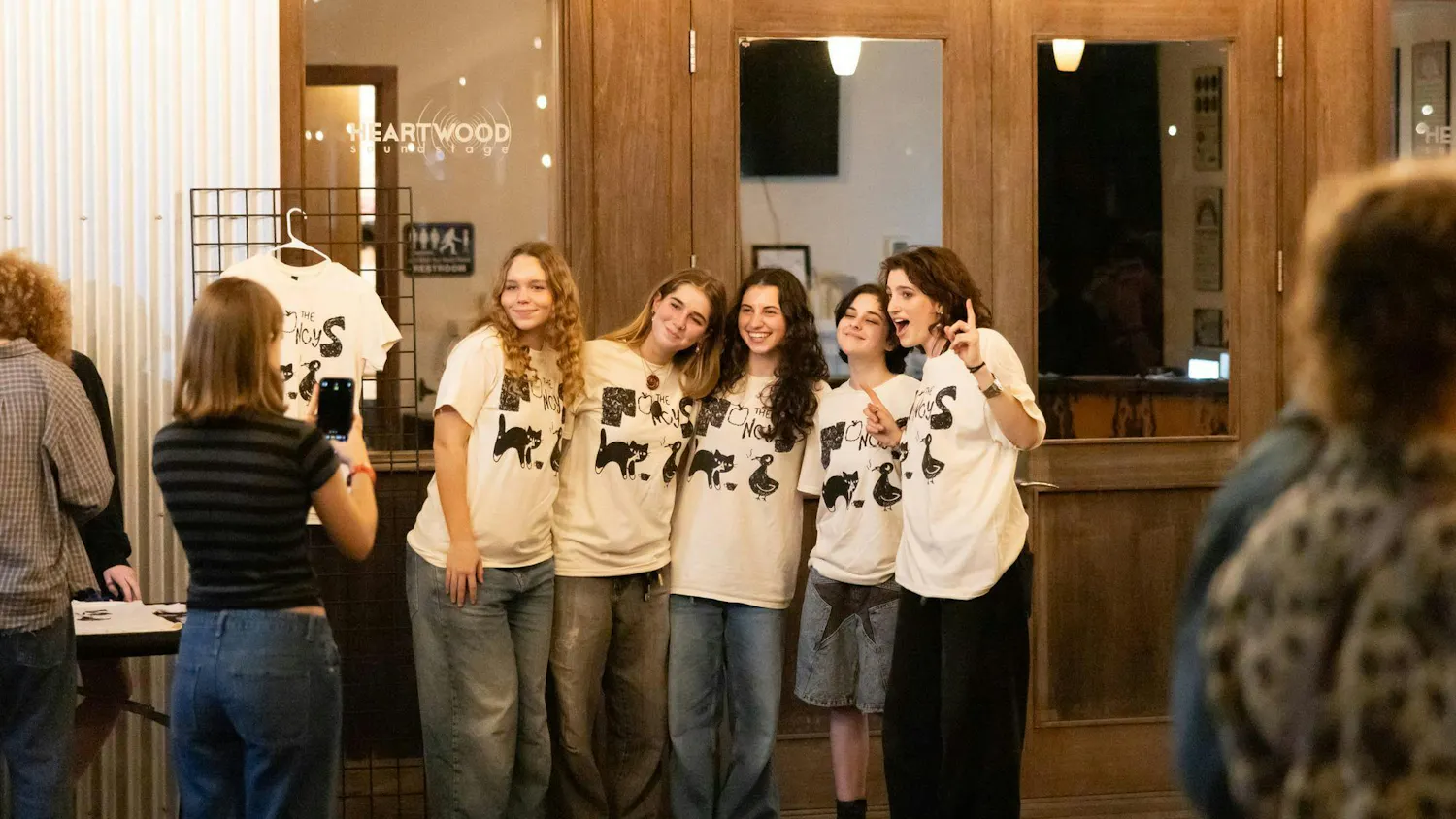 Fans of The Nancys pose in the band's merch at Heartwood Soundstage on Friday, Jan. 31, 2025.