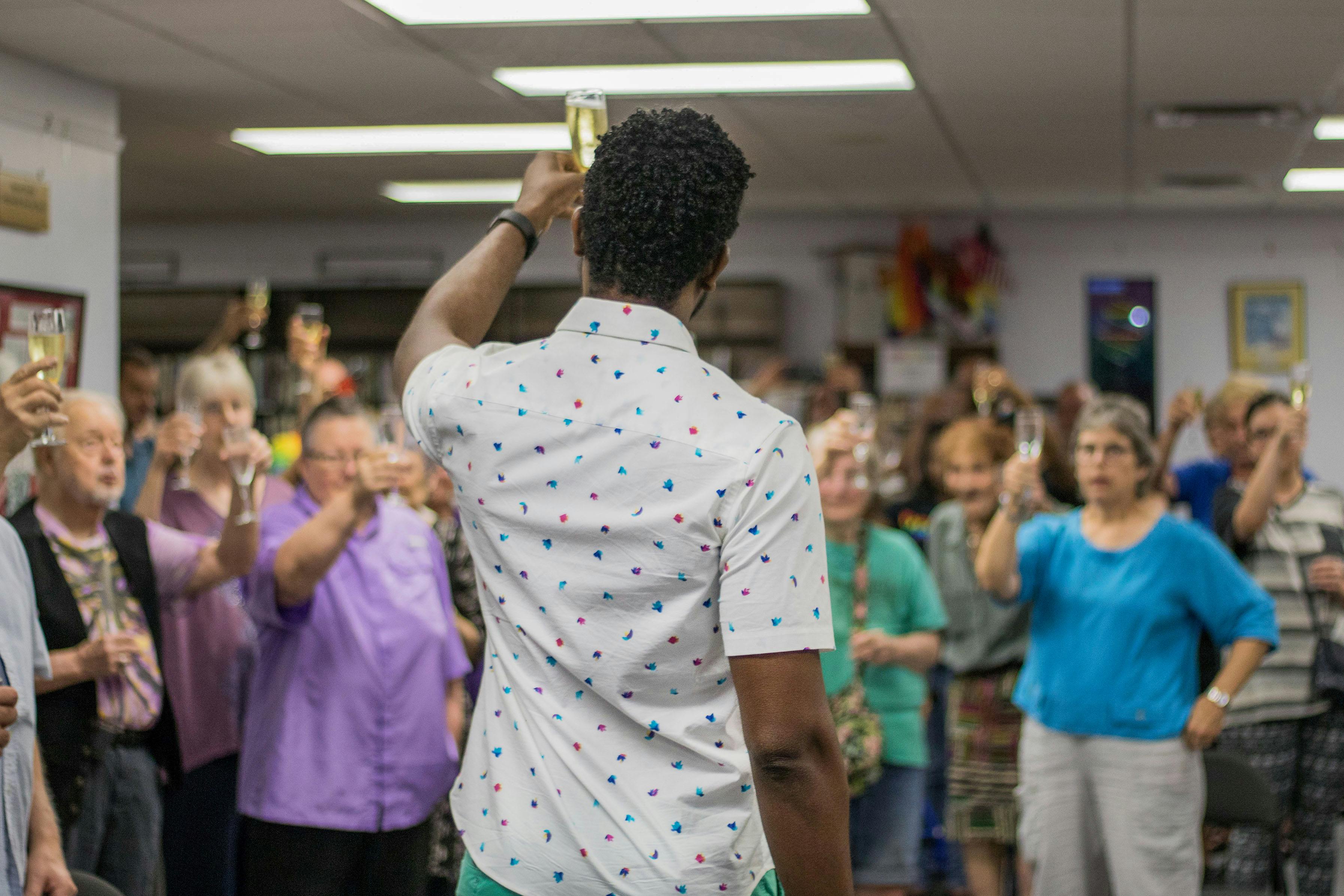 James Brown, 34, raises his glass Saturday night in a toast to the 50th anniversary of the Stonewall Riots and the progress the LGBTQ+ community has made during the Building on Our History Stonewall 50 Celebration party organized by the Pride Community Center of North Central Florida. The toast came after three speakers talked about the past struggles of the LGBTQ+ community, the progress the community has made and how to move forward. Over 50 people attended the event which offered food, refreshments and music.