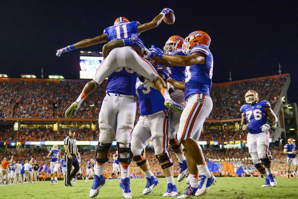 Demarcus Robinson (11) celebrates with teammates after scoring a touchdown in Florida's 36-30 triple-overtime win against Kentucky on Saturday at Ben Hill Griffin Stadium.