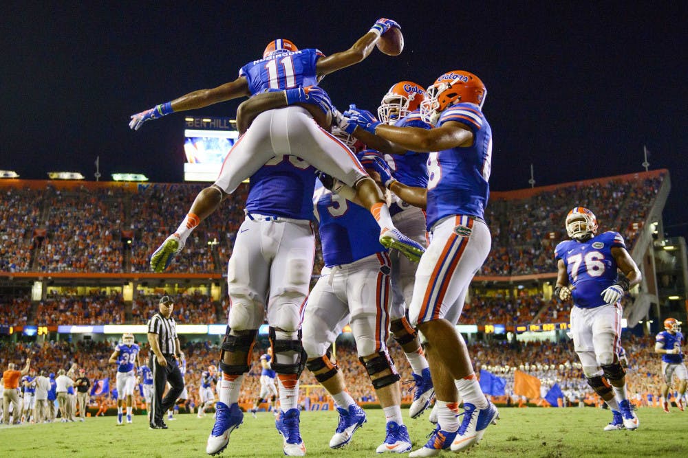 <p>Demarcus Robinson (11) celebrates with teammates after scoring a touchdown in Florida's 36-30 triple-overtime win against Kentucky on Saturday at Ben Hill Griffin Stadium.</p>