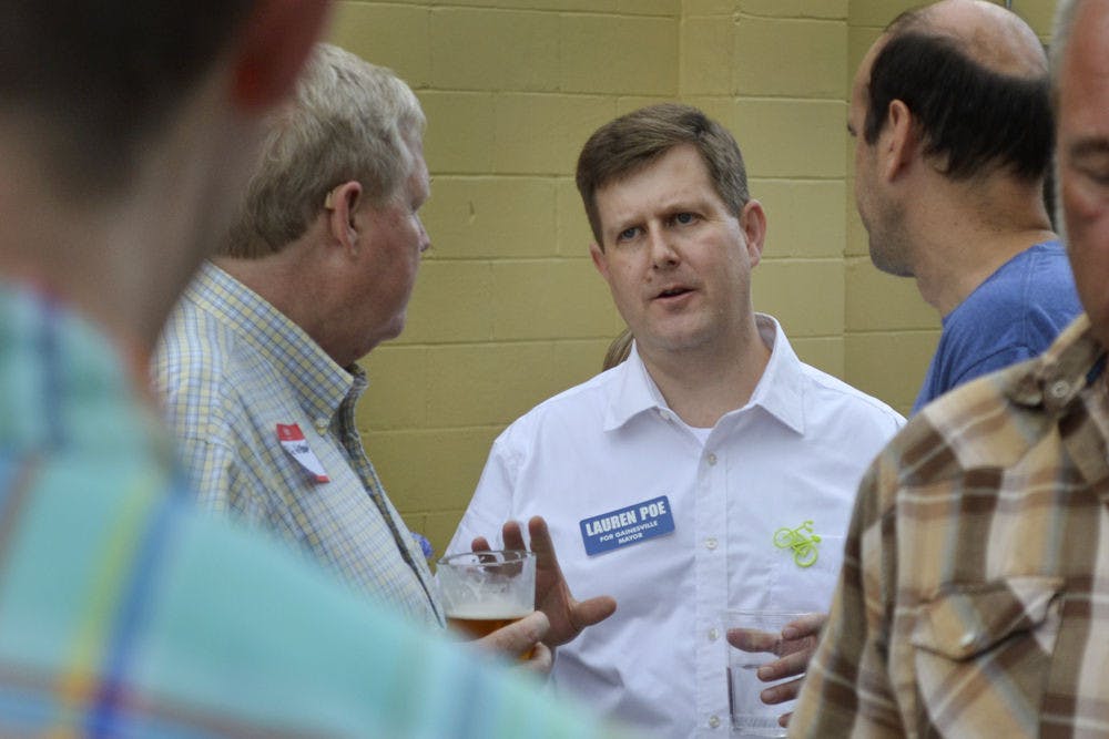 Gainesville mayoral candidate Lauren Poe mingles at his first fundraiser on Oct. 9, 2015, at First Magnitude Brewery. During his speech, Poe said he plans to focus on children, quality of life and transportation.