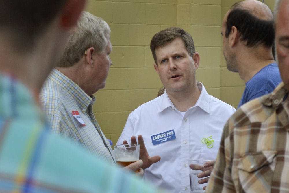<p>Gainesville mayoral candidate Lauren Poe mingles at his first fundraiser on Oct. 9, 2015, at First Magnitude Brewery. During his speech, Poe said he plans to focus on children, quality of life and transportation.</p>