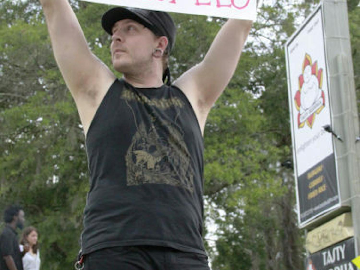 Striking Tasty Buddha cook Dustin Horn protests outside the restaurant Saturday. Employees say there has been a history of bounced checks.
