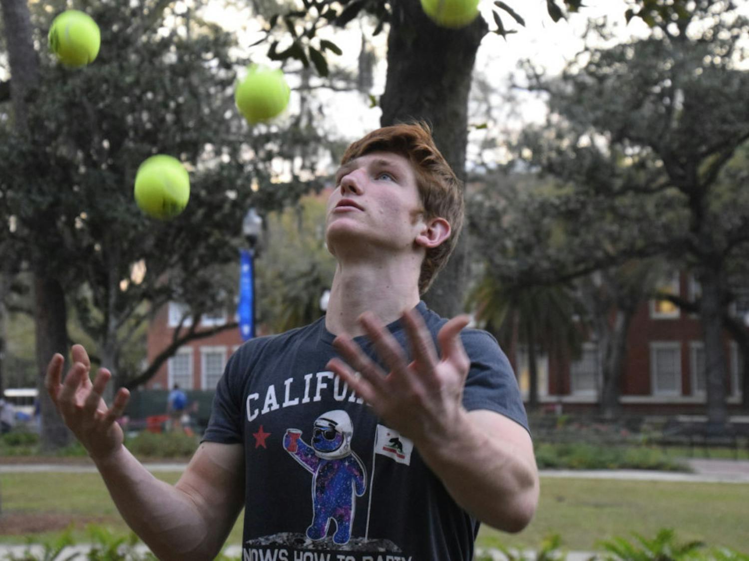 Devin Pryor, a 20-year-old UF aerospace engineering sophomore, juggles in front of Library West on Tuesday. It was one of his first meetings with UF Juggling Guys.