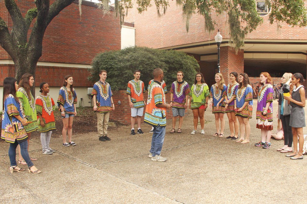 Abbey Chokera, director of the UF Pazeni Sauti Africa Choir, leads the group during a song at a promotional recruitment Tuesday in Turlington Plaza. Chokera said the group’s goal is to share the music with joy.