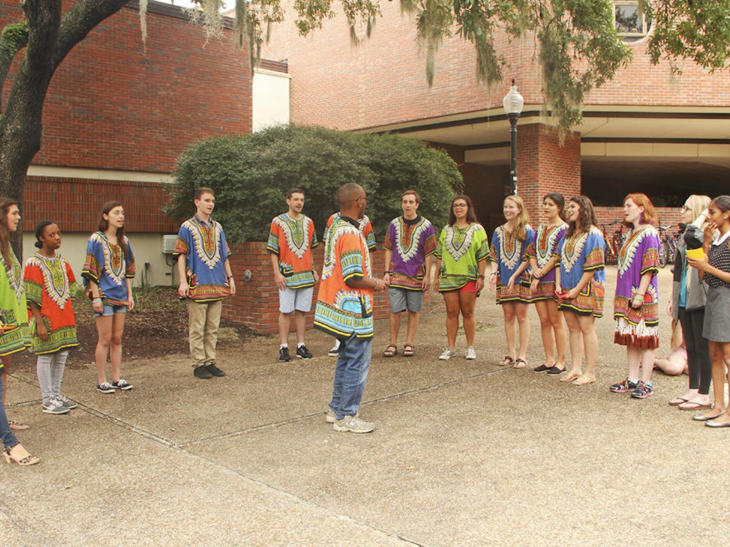 Abbey Chokera, director of the UF Pazeni Sauti Africa Choir, leads the group during a song at a promotional recruitment Tuesday in Turlington Plaza. Chokera said the group’s goal is to share the music with joy.