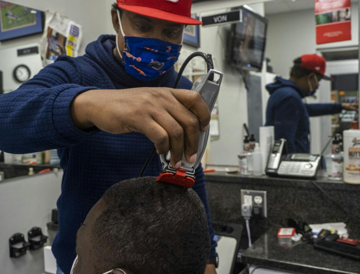 Von Brockington, a barber at The Reitz Union Barber Shop, is seen trimming John Smith’s hair on Monday, Oct. 19, 2020.