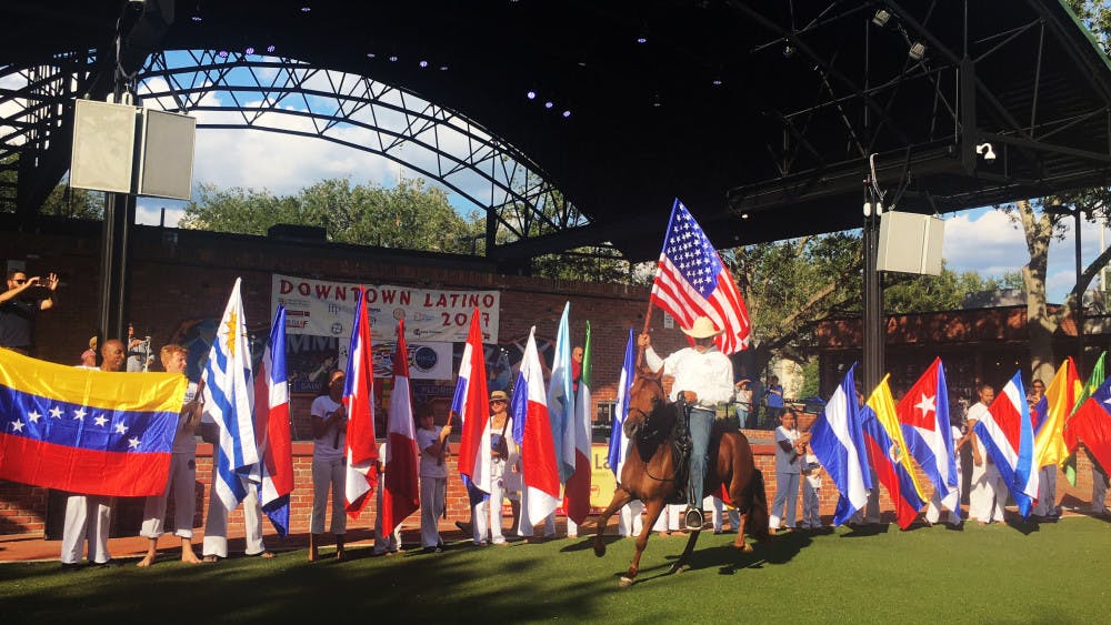 Children line up in front of the stage on Bo Diddley Community Plaza to welcome all Hispanic nations to the 15th annual Latin Festival on Saturday. To unite all of the nations, a horse rider rode out with an American flag.