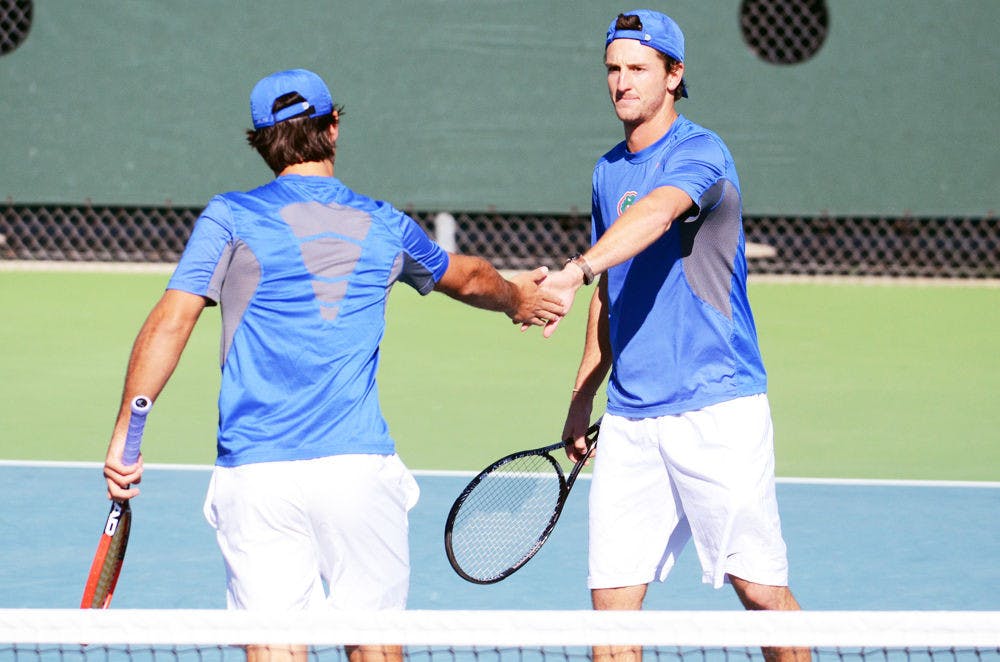 <p>Gordon Watson (right) high fives teammate Diego Hidalgo (left) during a doubles match in Florida's 9-3 win against William &amp; Mary on Friday at the Ring Tennis Complex.</p>